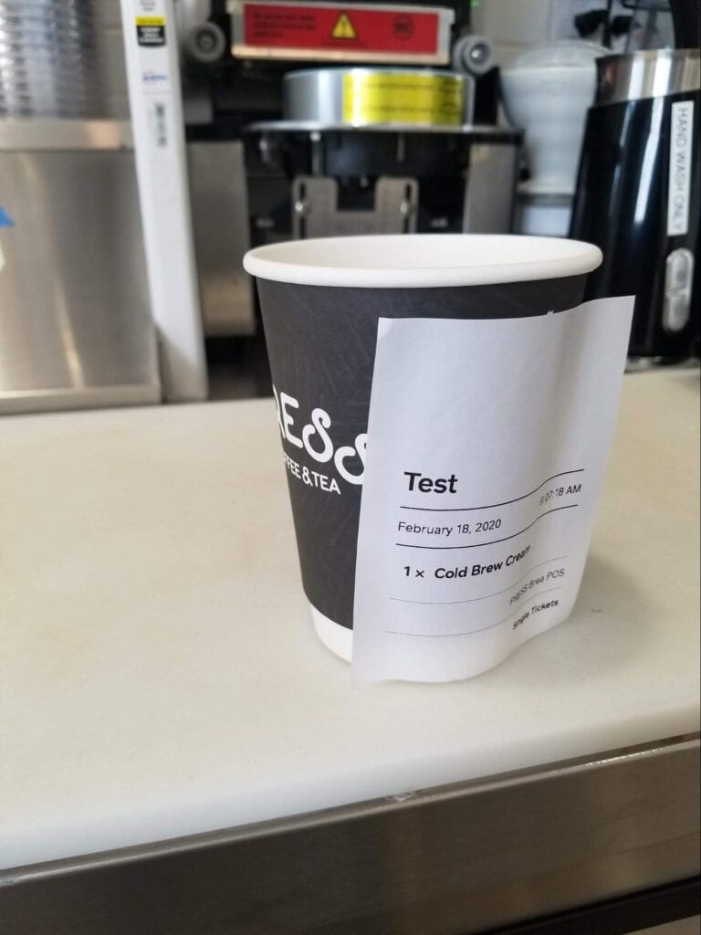 Photo showing a Clover printed label adhered to a paper coffee cup