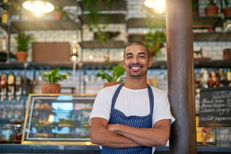 young latino business owner in front of his store