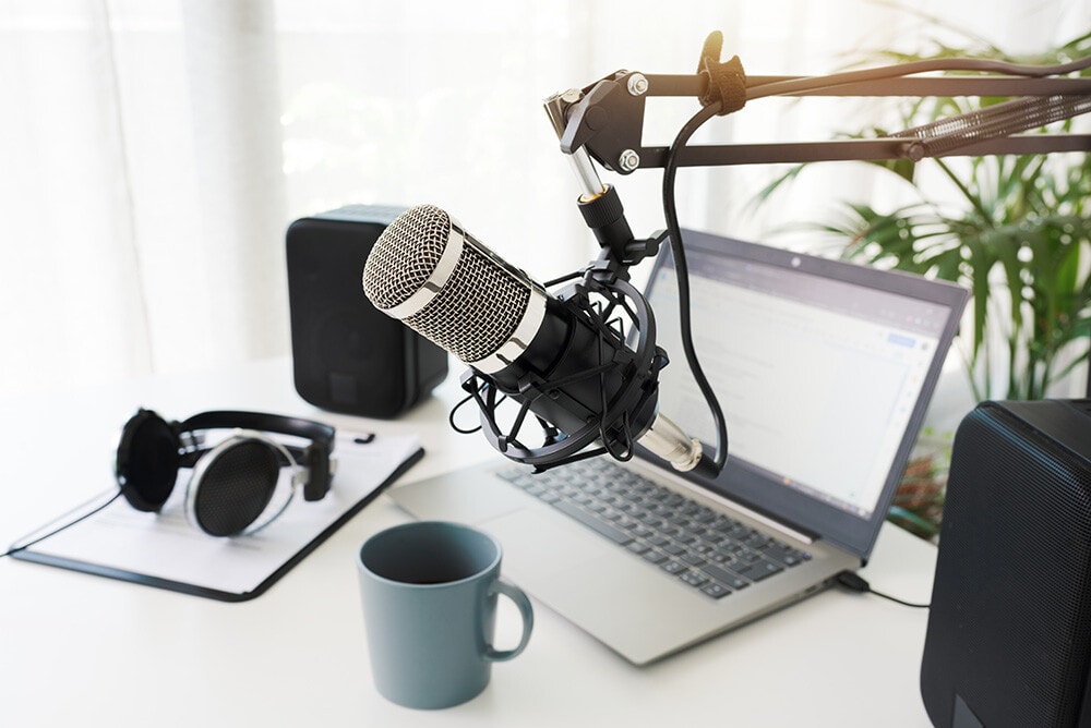 Podcast estudio con micrófono, laptop y café, portátil