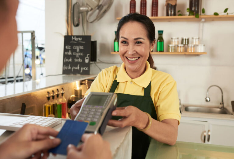 Latina accepting credit card payment at her restaurant
