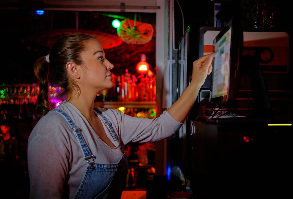 female bartender using fresh kds screen