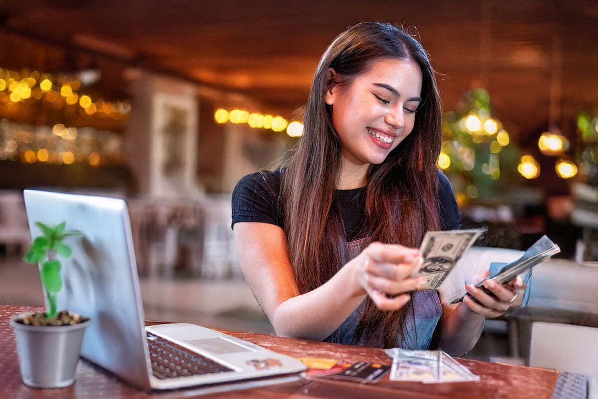 Young woman restaurant owner counting cash