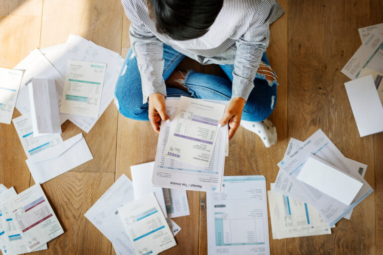 Man sorting out a pile of bills on the floor