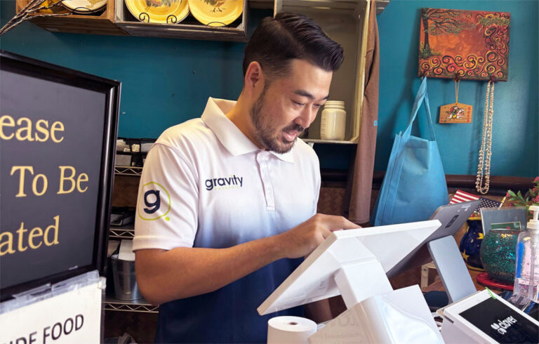 Gravity Payments deployment team member Mat smiling and installing terminals